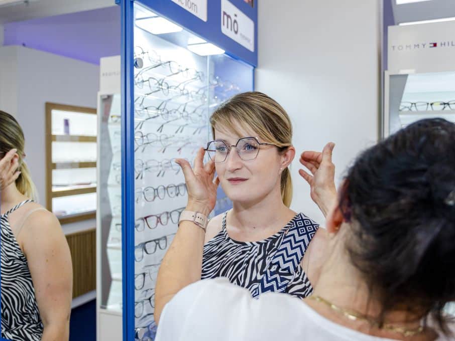 Молода жінка обирає окуляри з консультантом зі стилю